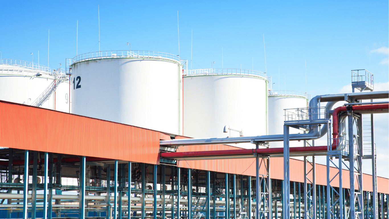 Industrial facility featuring large white storage tanks and extensive piping infrastructure used for water reclamation and water reuse operations, showing how stormwater, city process water, and sewage streams can be recycled and treated to produce high-quality non-potable and even drinking water for industrial and agriculture applications. This image illustrates how modern treatment systems allow facilities to purify and reuse the same water multiple times, similar to the way a water reclamation district manages municipal recycling and cleaning processes. The scene serves as an example of infrastructure that is applicable to both industrial and government water-management initiatives, demonstrating methods that can be described on an office page or technical resource site, and showing how reclaimed water can be integrated into subsequent treatment stages used in virtually any large commercial or municipal operation.